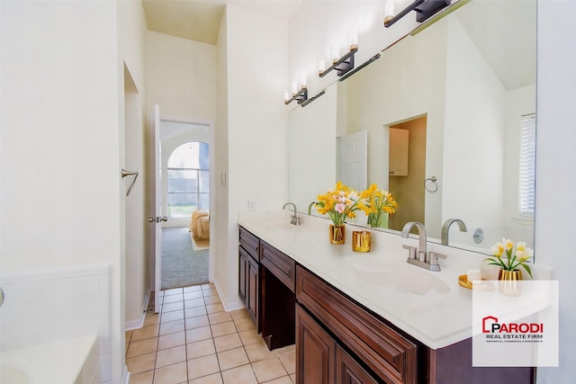 bathroom featuring tile patterned flooring, a tub to relax in, and vanity