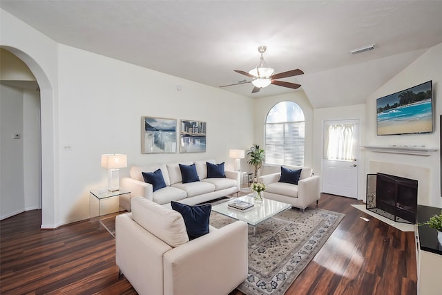 living room with ceiling fan, dark hardwood / wood-style floors, and vaulted ceiling