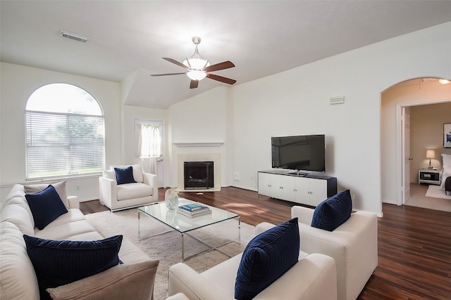 living room featuring dark hardwood / wood-style flooring, vaulted ceiling, and ceiling fan