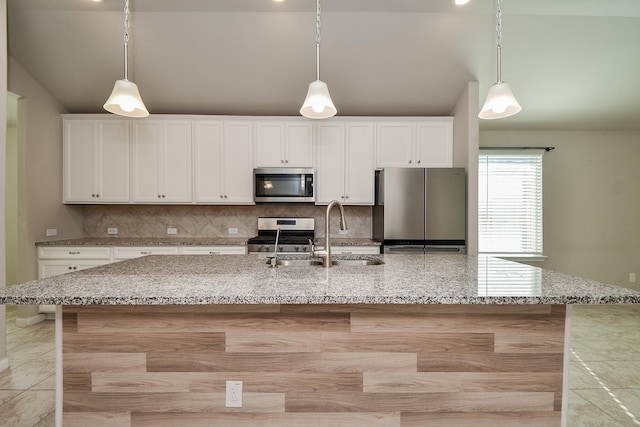 kitchen featuring a large island with sink, white cabinets, sink, light stone counters, and stainless steel appliances