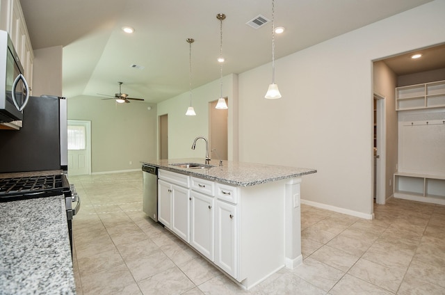 kitchen with pendant lighting, white cabinets, sink, light stone countertops, and appliances with stainless steel finishes