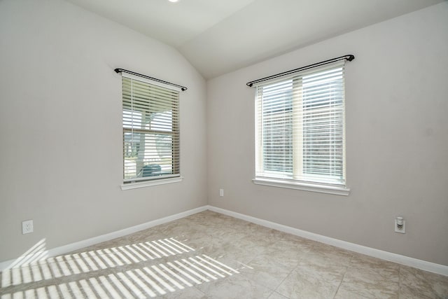 unfurnished room featuring vaulted ceiling