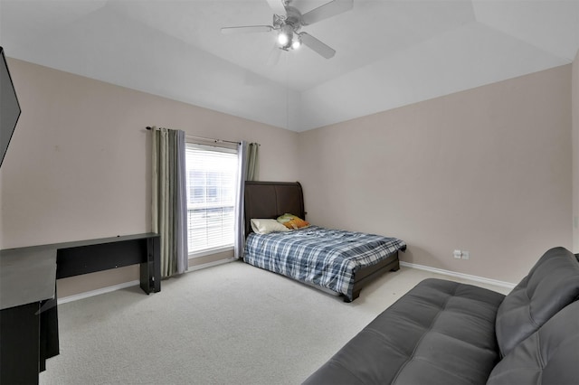 carpeted bedroom with ceiling fan and a tray ceiling