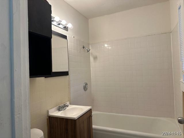 full bathroom featuring vanity, toilet, and tiled shower / bath combo