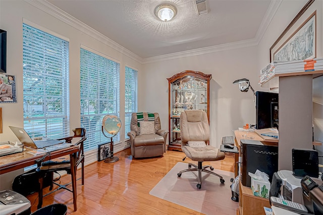 home office featuring hardwood / wood-style floors, ornamental molding, and a textured ceiling