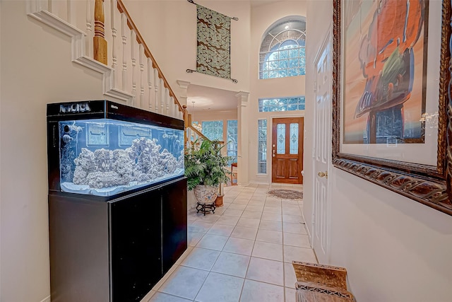 foyer entrance with light tile patterned floors and a high ceiling