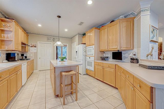 kitchen with pendant lighting, white appliances, tasteful backsplash, a kitchen island, and a kitchen bar