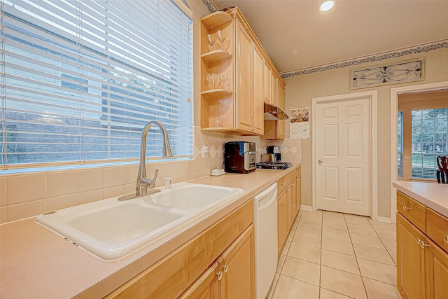 kitchen featuring light brown cabinetry, white dishwasher, sink, light tile patterned floors, and stainless steel gas stovetop