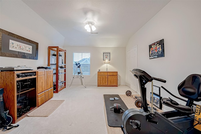 exercise area with light carpet and vaulted ceiling