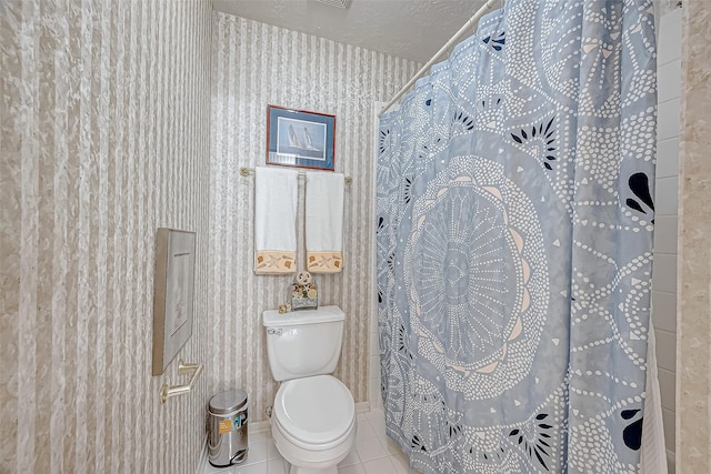 bathroom featuring tile patterned floors, toilet, a textured ceiling, and walk in shower