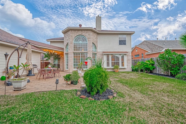 rear view of house featuring a patio area and a yard