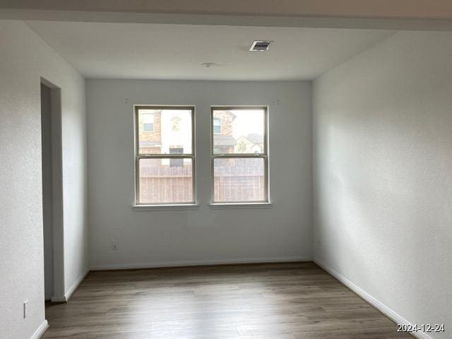 unfurnished room with hardwood / wood-style flooring