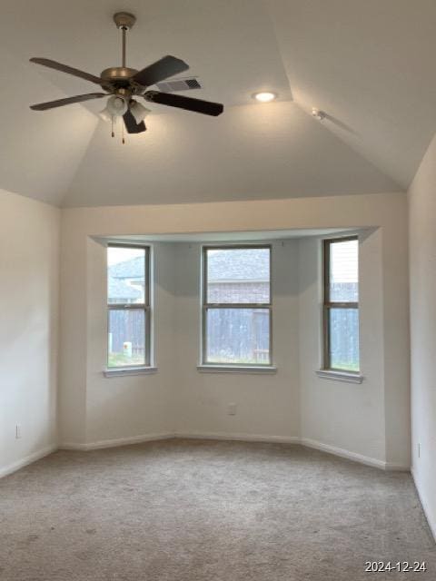 carpeted spare room featuring ceiling fan and lofted ceiling