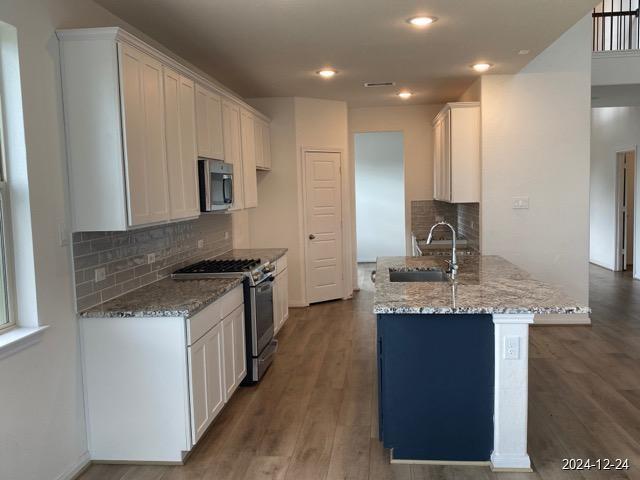 kitchen with white cabinets, light stone countertops, sink, and appliances with stainless steel finishes