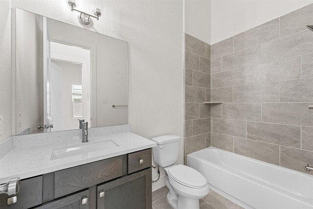 full bathroom with tile patterned flooring, vanity, toilet, and tiled shower / bath