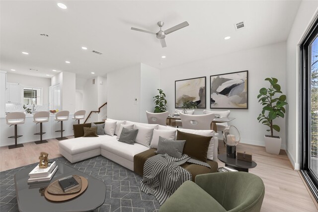 living room featuring light hardwood / wood-style flooring and ceiling fan