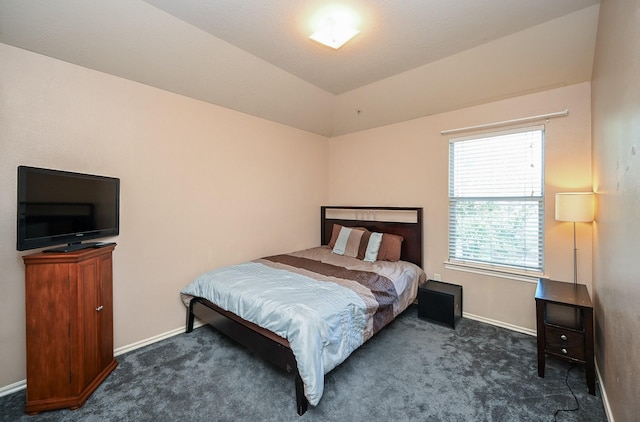 bedroom with dark carpet and lofted ceiling