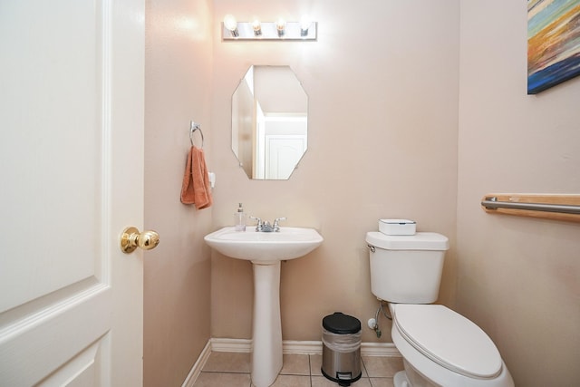 bathroom with toilet, tile patterned floors, and sink