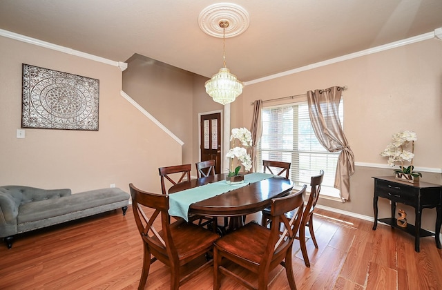 dining room featuring wood-type flooring, crown molding, and an inviting chandelier