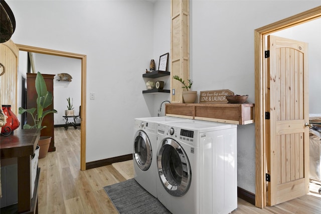 washroom with light hardwood / wood-style floors and washer and clothes dryer