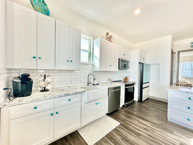 kitchen featuring backsplash, sink, dark hardwood / wood-style floors, appliances with stainless steel finishes, and white cabinetry