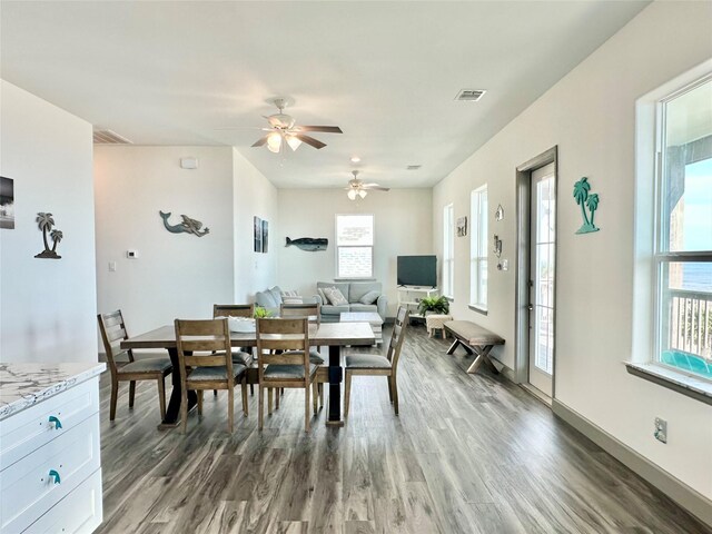 dining space with ceiling fan and dark hardwood / wood-style flooring