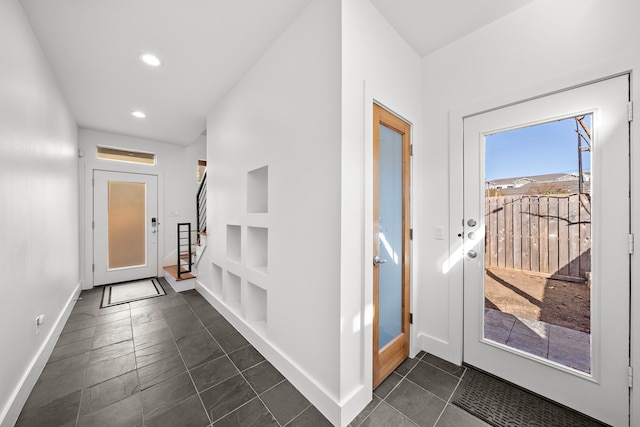 doorway with dark tile patterned flooring and built in features