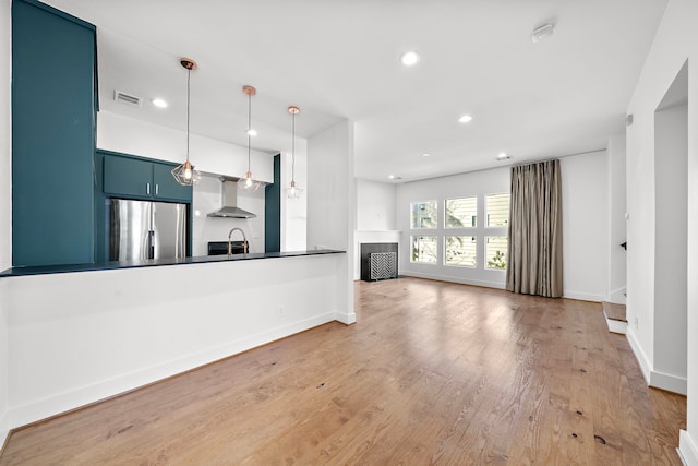 unfurnished living room featuring hardwood / wood-style flooring and sink