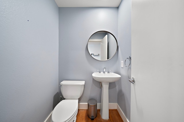 bathroom featuring hardwood / wood-style floors and toilet