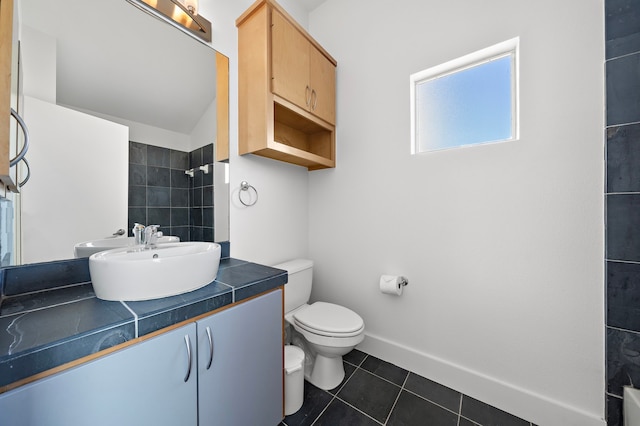 bathroom with tile patterned flooring, vanity, toilet, and lofted ceiling