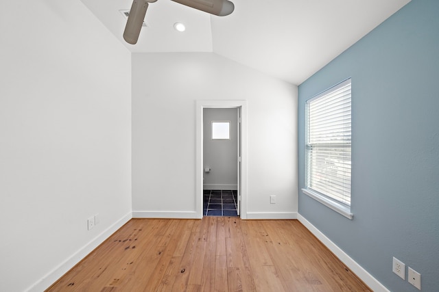 empty room featuring ceiling fan, light wood-type flooring, and vaulted ceiling