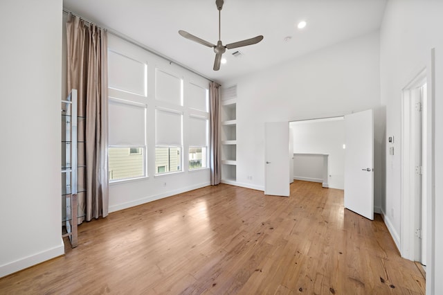 unfurnished living room featuring ceiling fan, light hardwood / wood-style floors, and built in features