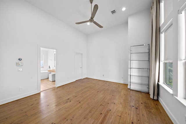 spare room with ceiling fan, light wood-type flooring, and high vaulted ceiling