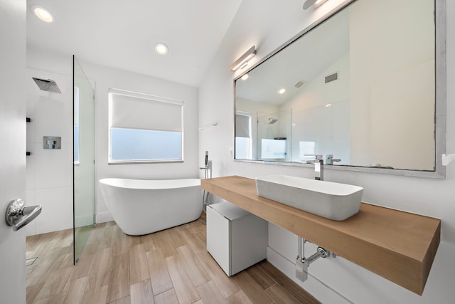 bathroom featuring separate shower and tub, lofted ceiling, and sink