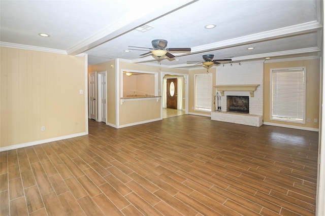 unfurnished living room featuring wood-type flooring, a brick fireplace, and ornamental molding