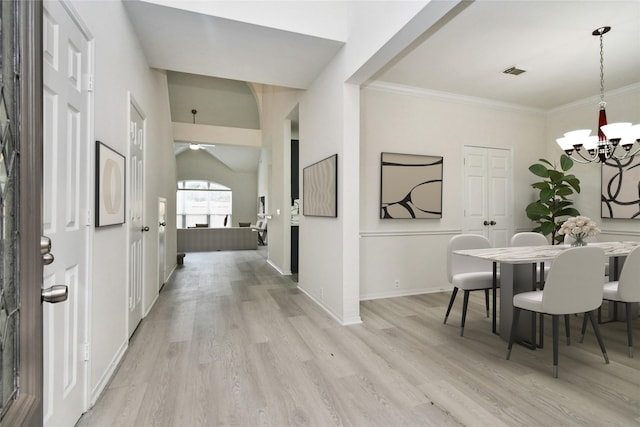 interior space featuring ceiling fan with notable chandelier, light wood-type flooring, and crown molding