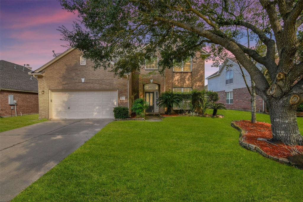 view of front facade featuring a garage and a lawn