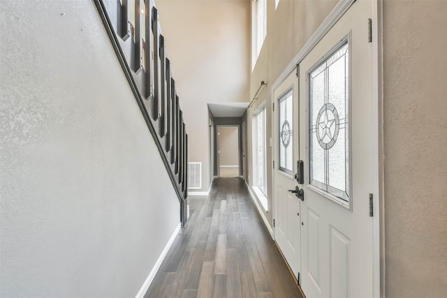 entrance foyer featuring dark hardwood / wood-style floors and a towering ceiling