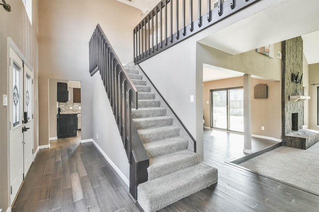 staircase with a high ceiling and hardwood / wood-style flooring