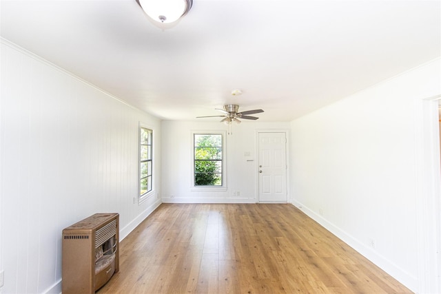 spare room with ceiling fan, light wood-type flooring, and heating unit