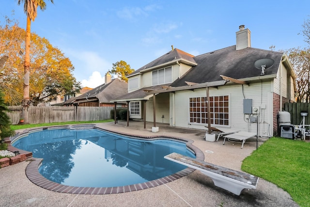 view of pool with a diving board and a patio