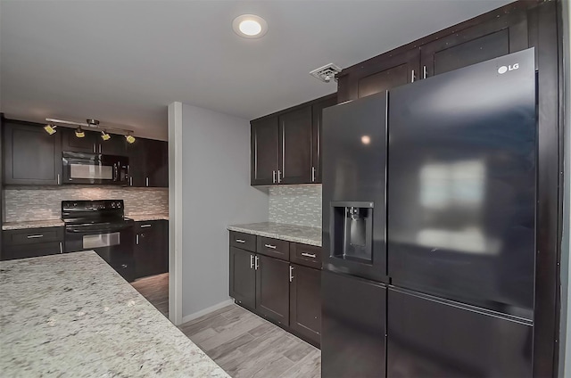 kitchen with backsplash, dark brown cabinetry, light stone countertops, and black appliances