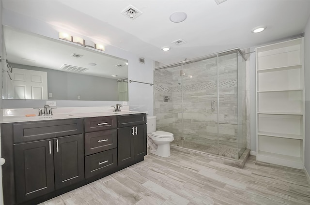 bathroom featuring hardwood / wood-style floors, vanity, toilet, and an enclosed shower