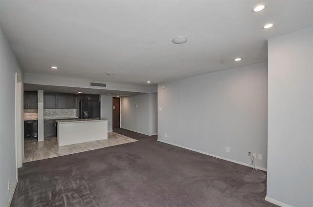 unfurnished living room featuring dark carpet