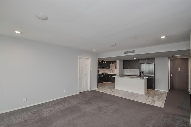 unfurnished living room featuring sink and light colored carpet