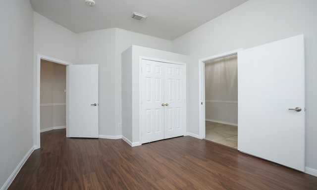 unfurnished bedroom with a closet and dark hardwood / wood-style floors