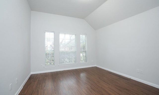 unfurnished room featuring vaulted ceiling, dark hardwood / wood-style flooring, and plenty of natural light