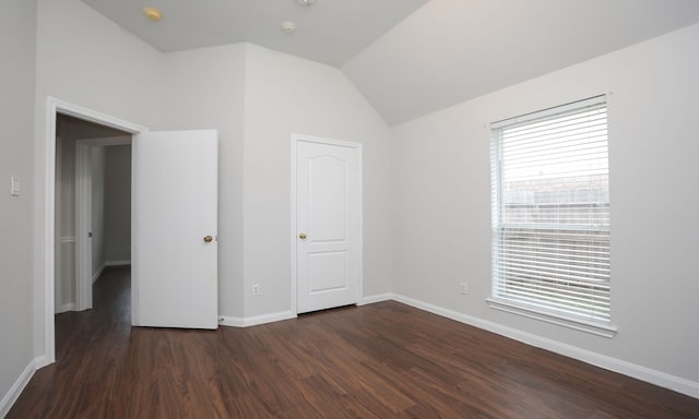 unfurnished bedroom featuring a closet, dark wood-type flooring, and vaulted ceiling