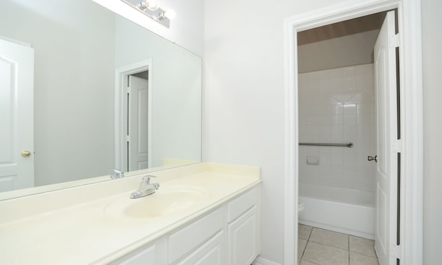 full bathroom with tile patterned floors, tiled shower / bath, vanity, and toilet