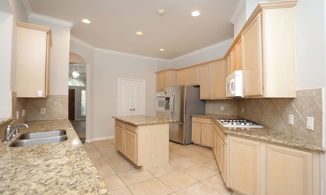 kitchen featuring white appliances, a center island, light stone countertops, and sink